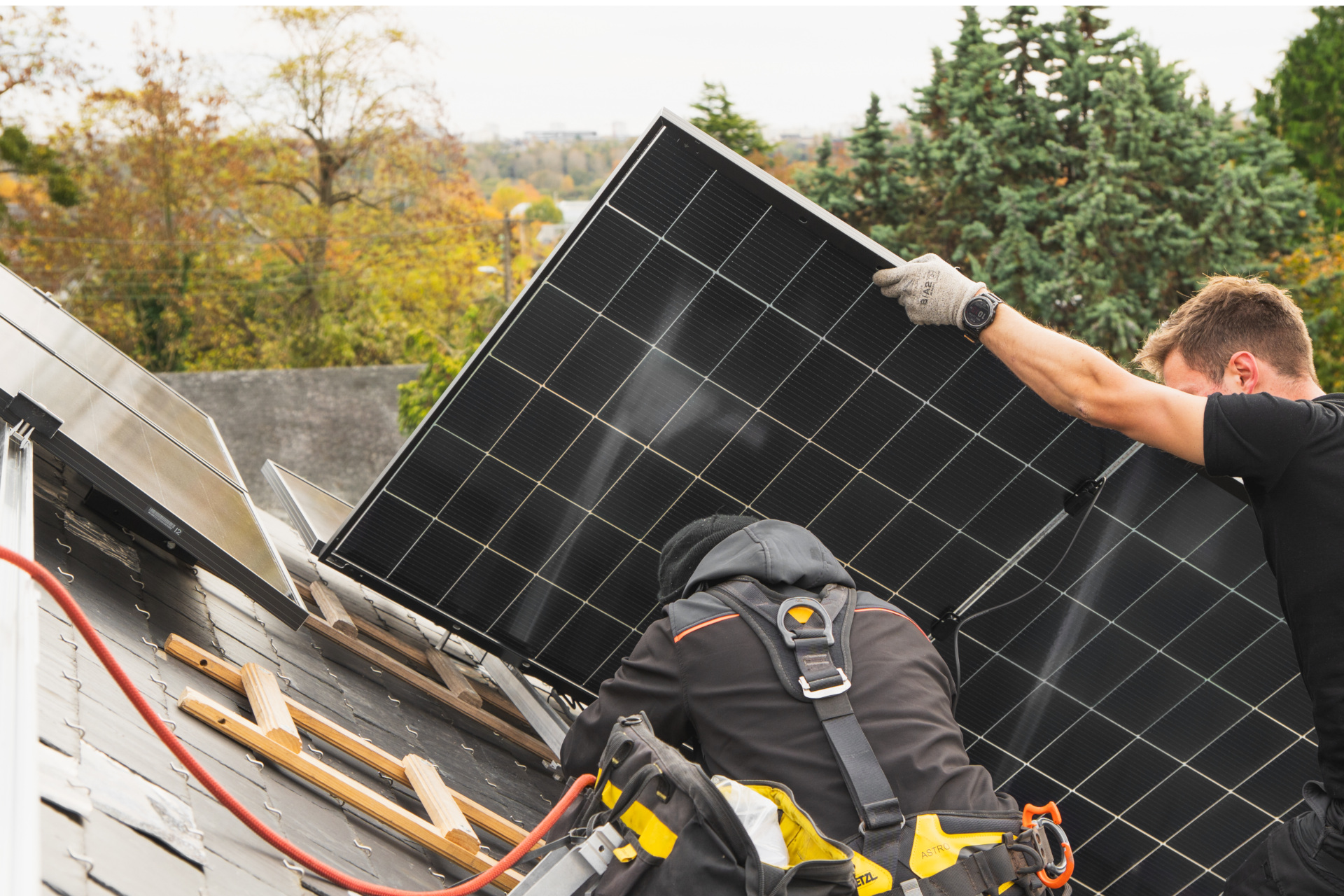 Un couvreur posant des paneaux solaires sur un toit